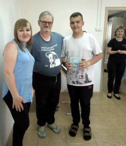boy receives an award from two teachers