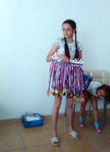 a girl shows us her running medals.