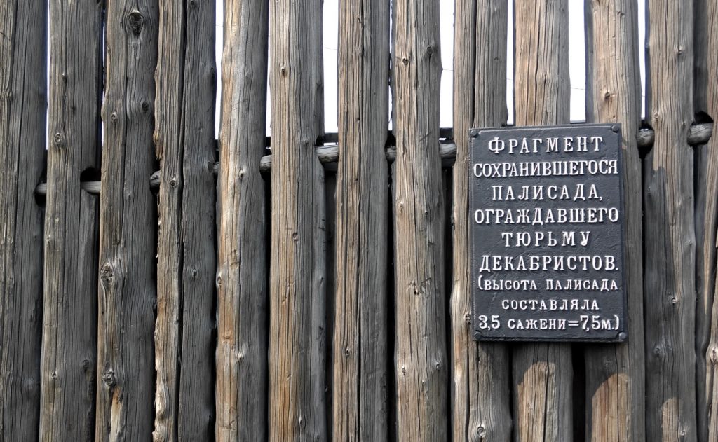 log stockade with descriptive sign in Russian