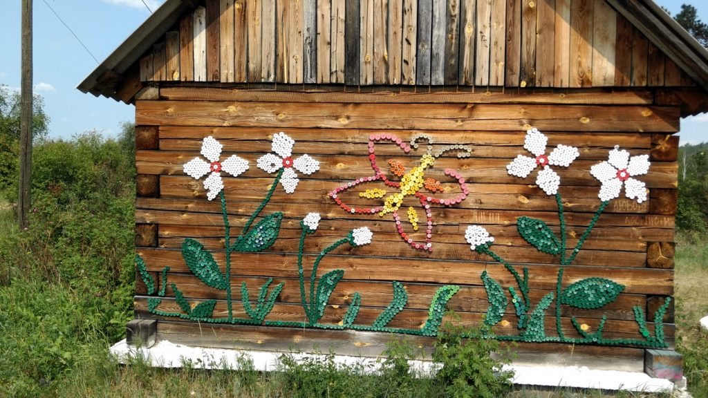 design of flowers on the side of a log house