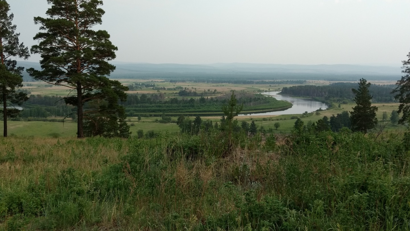 Siberian scenery, grassland, meandering river, hills, pines.