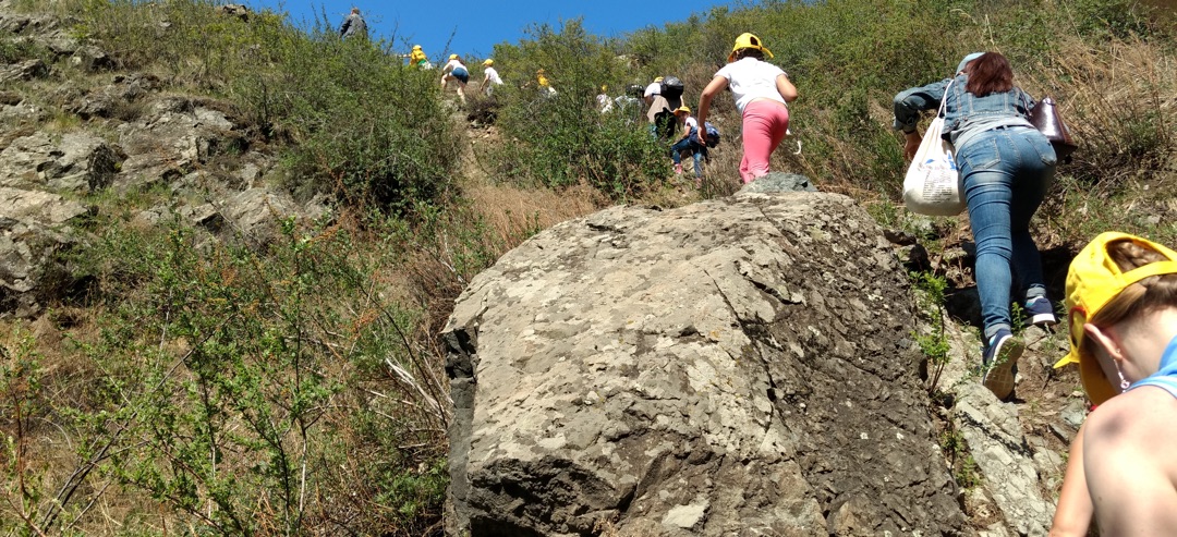 line of chidlren hiking up a steep incline