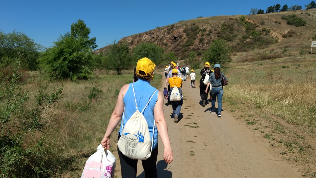 people hiking on a bright day dusty road