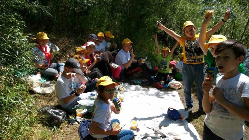 kids eating in the shade by the river