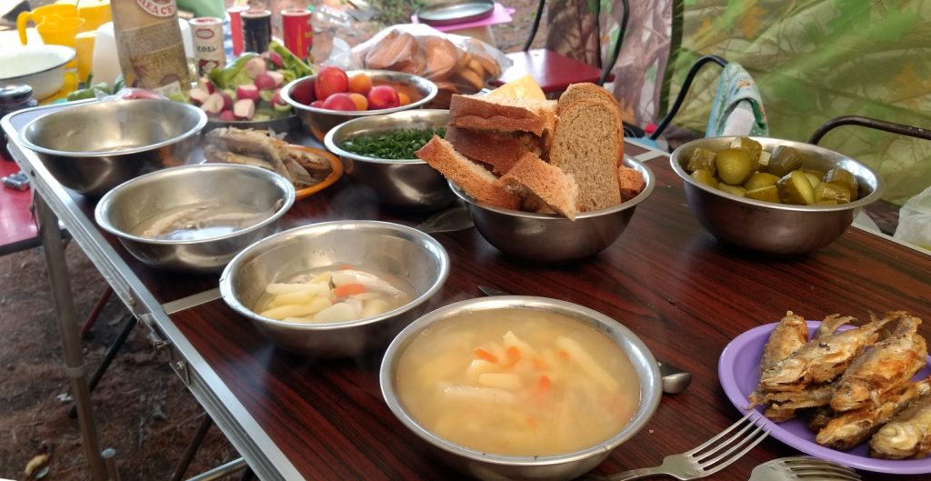 bowls of soup and small pan-fried fish with other dishes