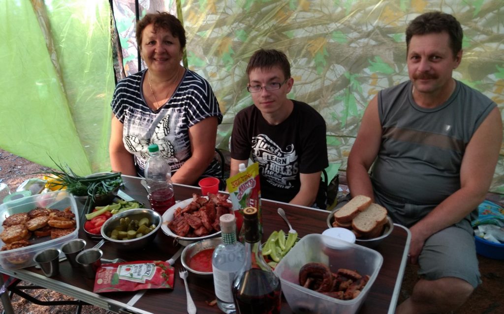 kitchen tent, 3 people, food ready to eat.