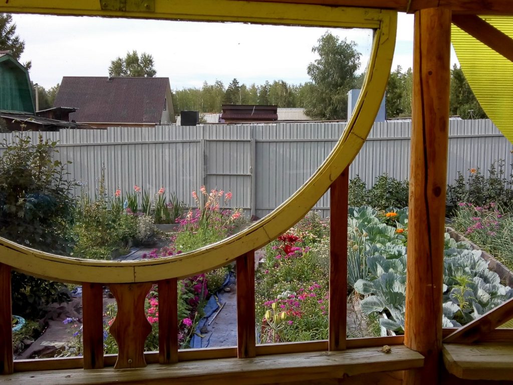 Fanciful windows on a gazebo with flower garden beyond