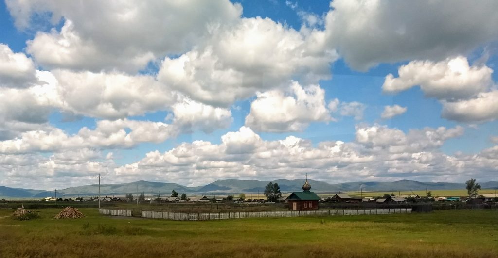 village on a big plain, mountains in the distance